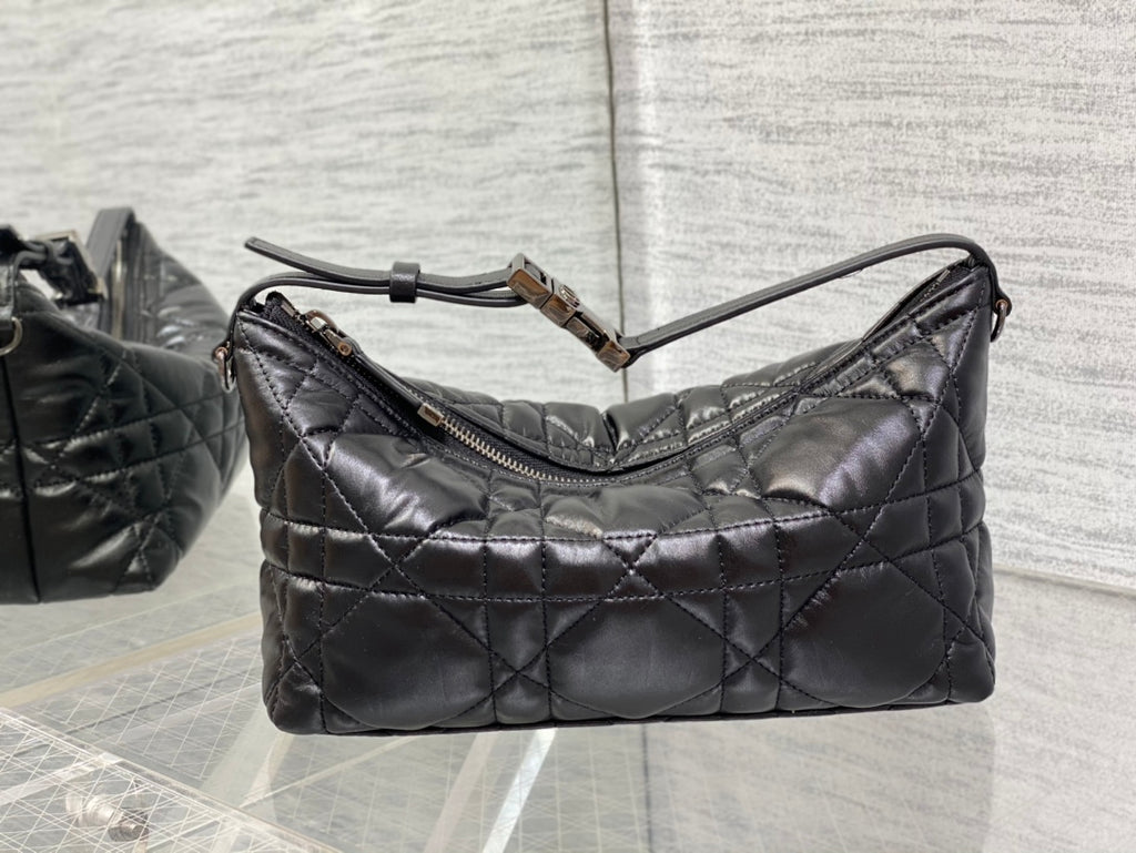 Quilted black Dior bag with curved top handles and shoulder strap