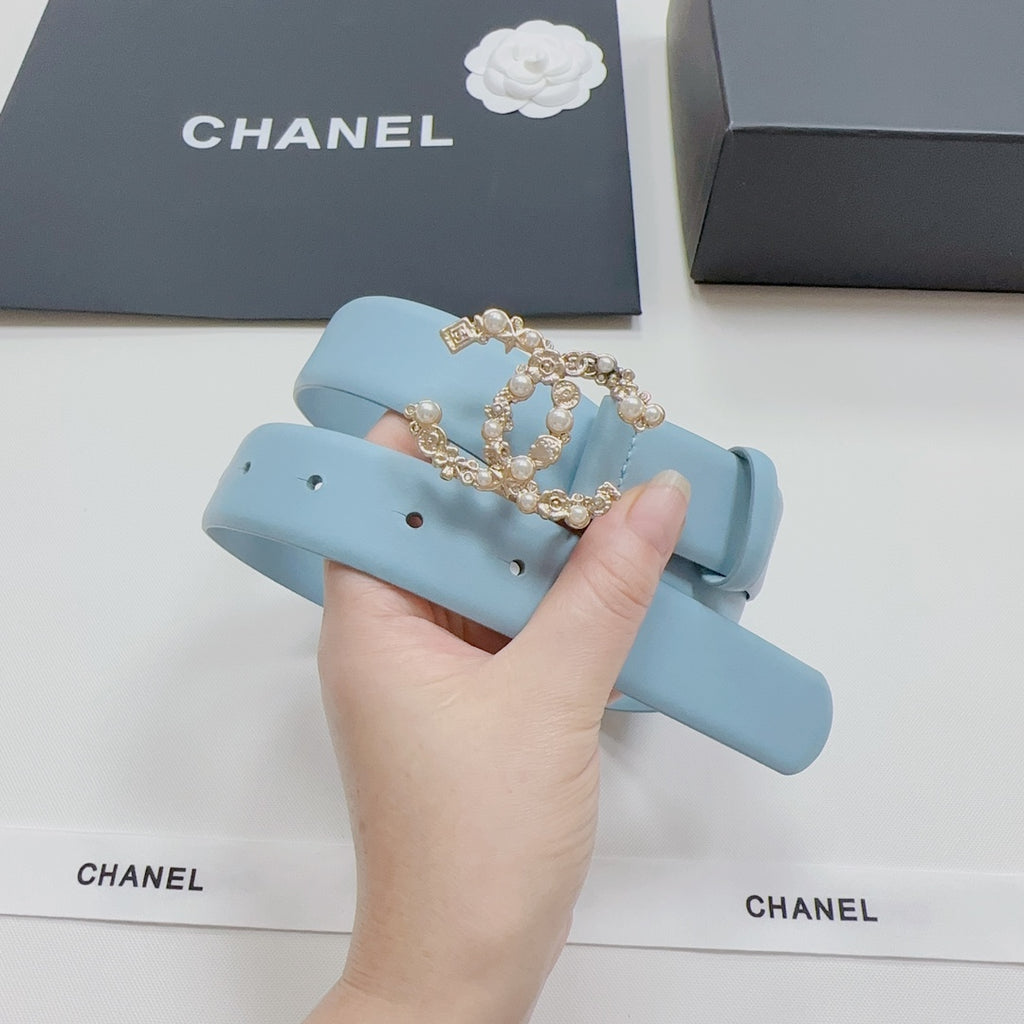 Light blue leather belt with ornate gold CC-style buckle in close-up