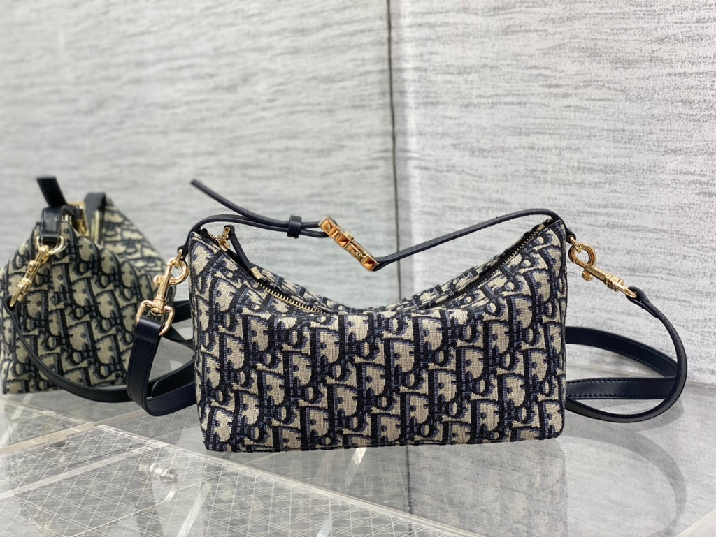 Dior shoulder bag with Dior monogram pattern, curved top, adjustable navy strap, gold ring