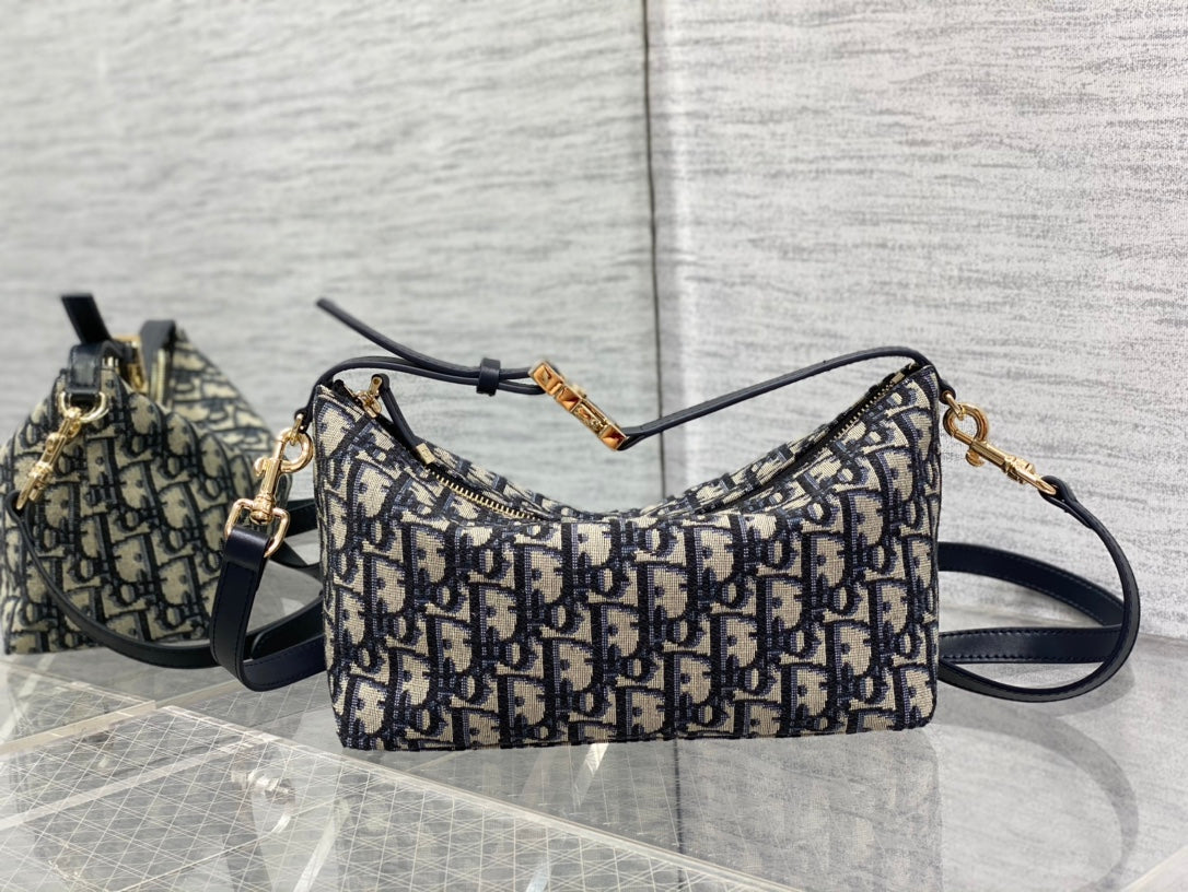Dior shoulder bag with Dior monogram pattern, curved top, adjustable navy strap, gold ring