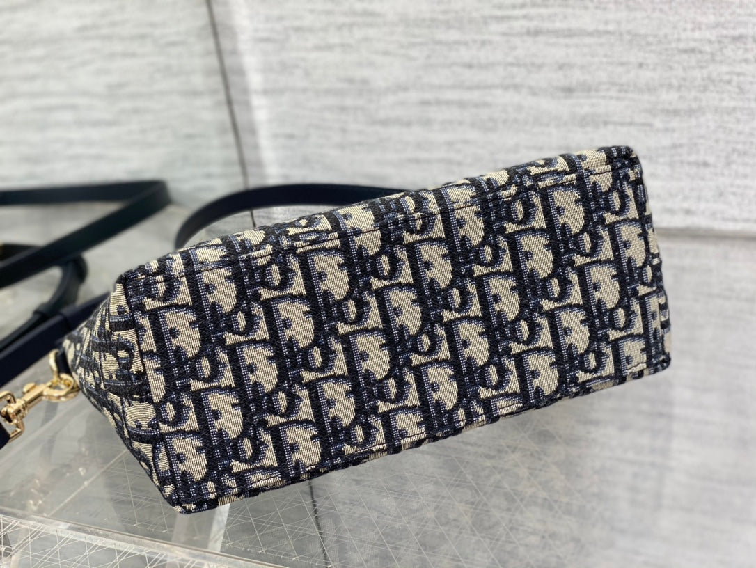 Dior bag side view with Dior monogram print canvas and rolled-top shape