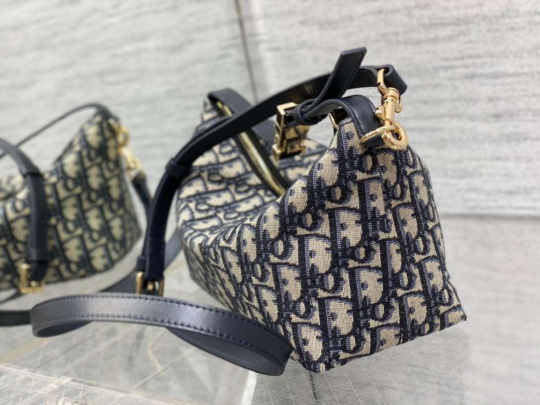 Dior monogram mini bag with structured top, navy strap, and gold-tone hardware detail
