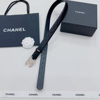 Chanel belt with dark quilted strap, gold buckle end and dangling pearl ornament