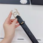 Chanel belt buckle detail: dark quilted strap with gold buckle and pearl floral frame