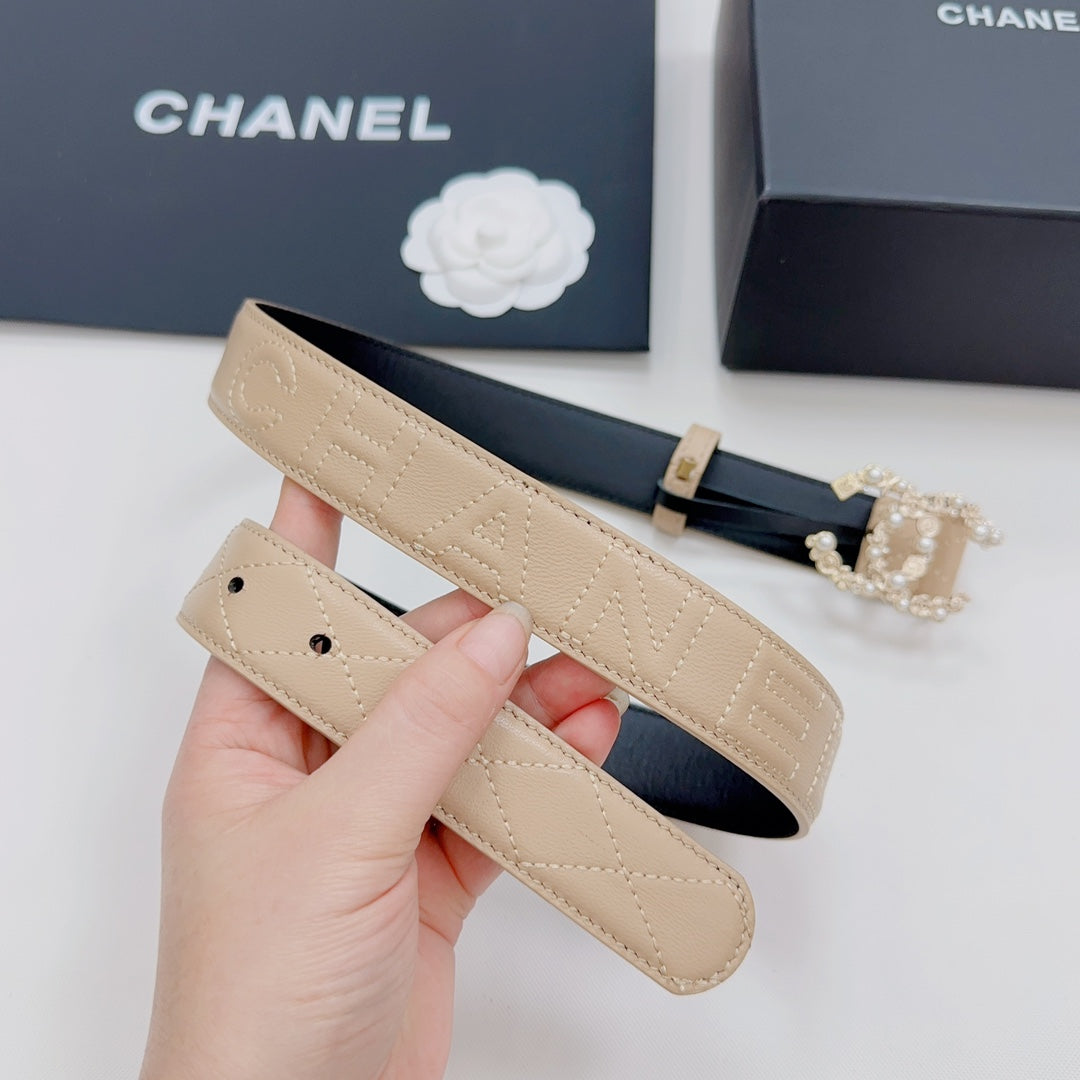 Beige Chanel belt with gold buckle, quilted texture, and rhinestone CC ornament