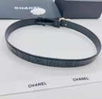 Chanel belt with dark strap featuring repeating 'CHANEL' logo pattern and gold buckle