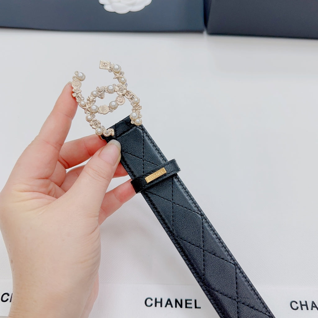 Chanel belt close-up: dark leather strap with gold buckle and floral pearl embellishment