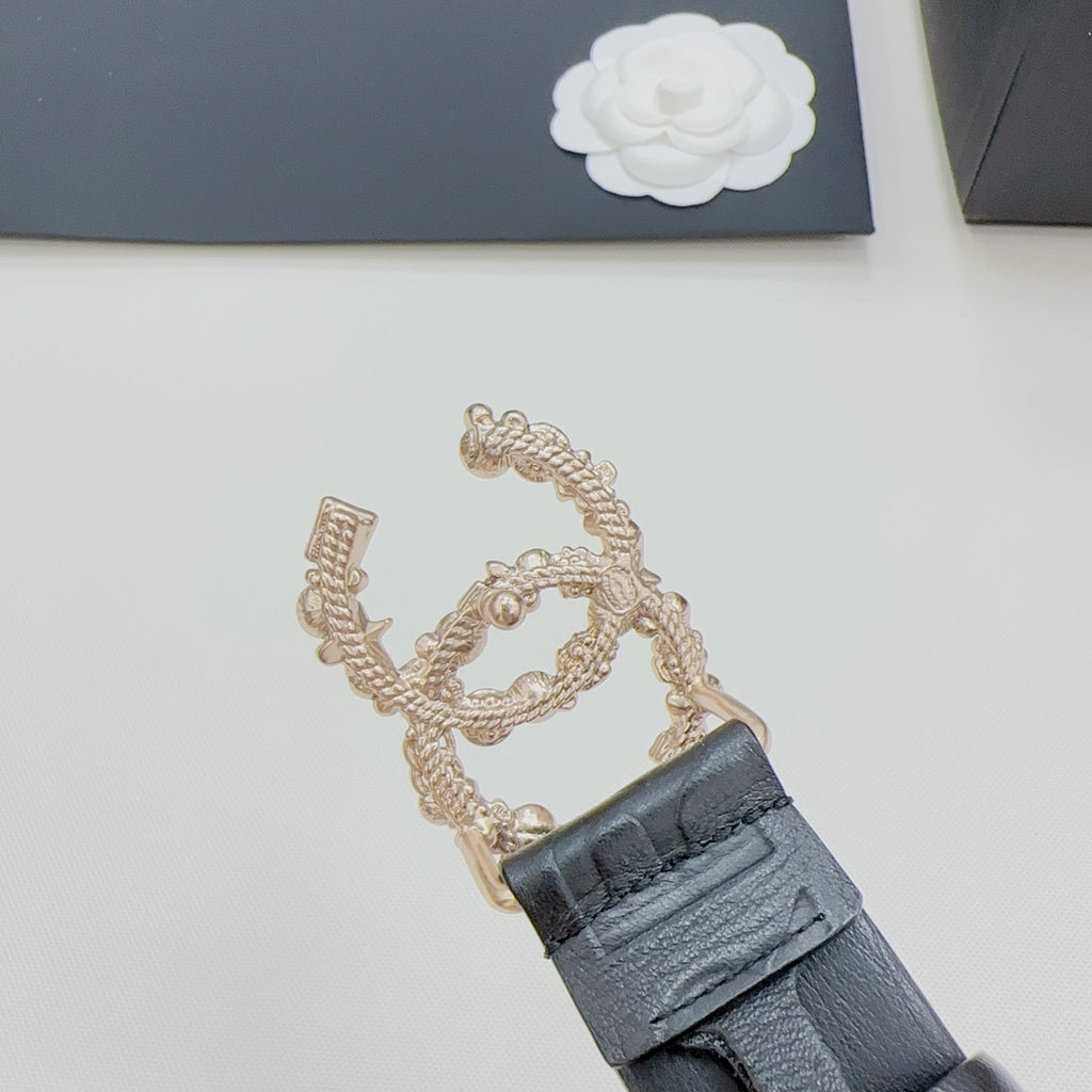 Chanel belt clasp detail with gold chain and dark blue leather strap and buckle