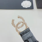 Chanel belt clasp detail with gold chain and dark blue leather strap and buckle