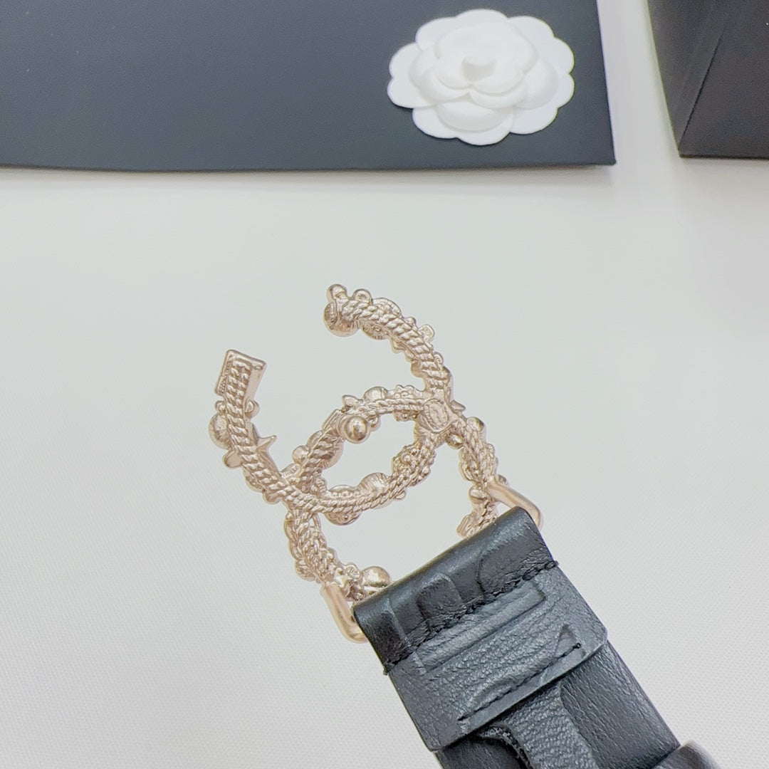 Chanel belt clasp detail with gold chain and dark blue leather strap and buckle