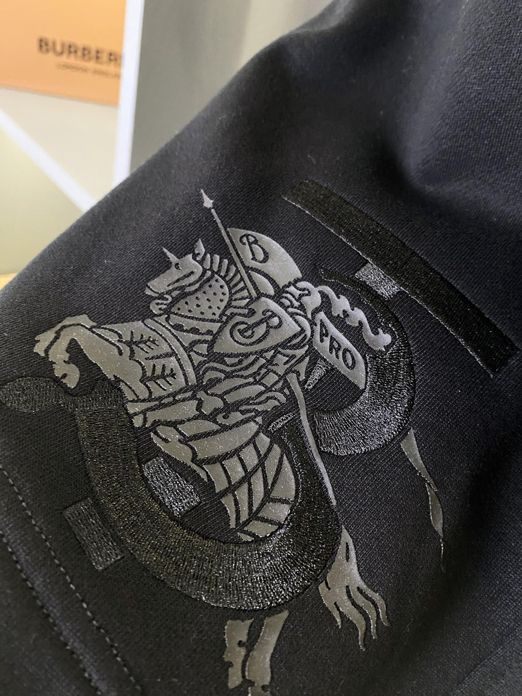 Black Burberry shorts with detailed embroidered lion crest graphic