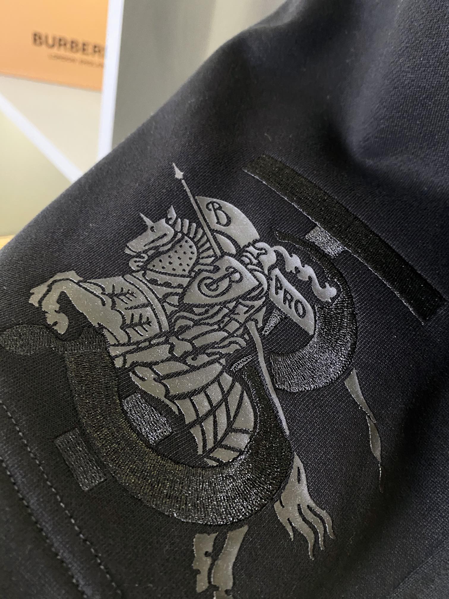 Black Burberry shorts with detailed embroidered lion crest graphic