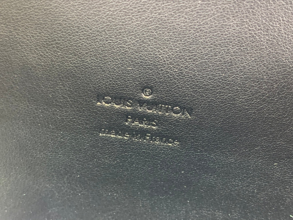 Louis Vuitton embossed logo on brown leather surface