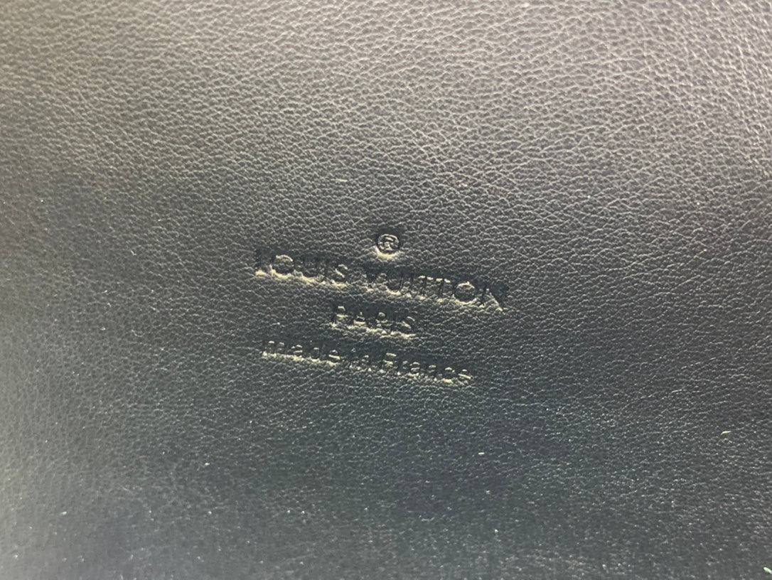 Louis Vuitton embossed logo on brown leather surface