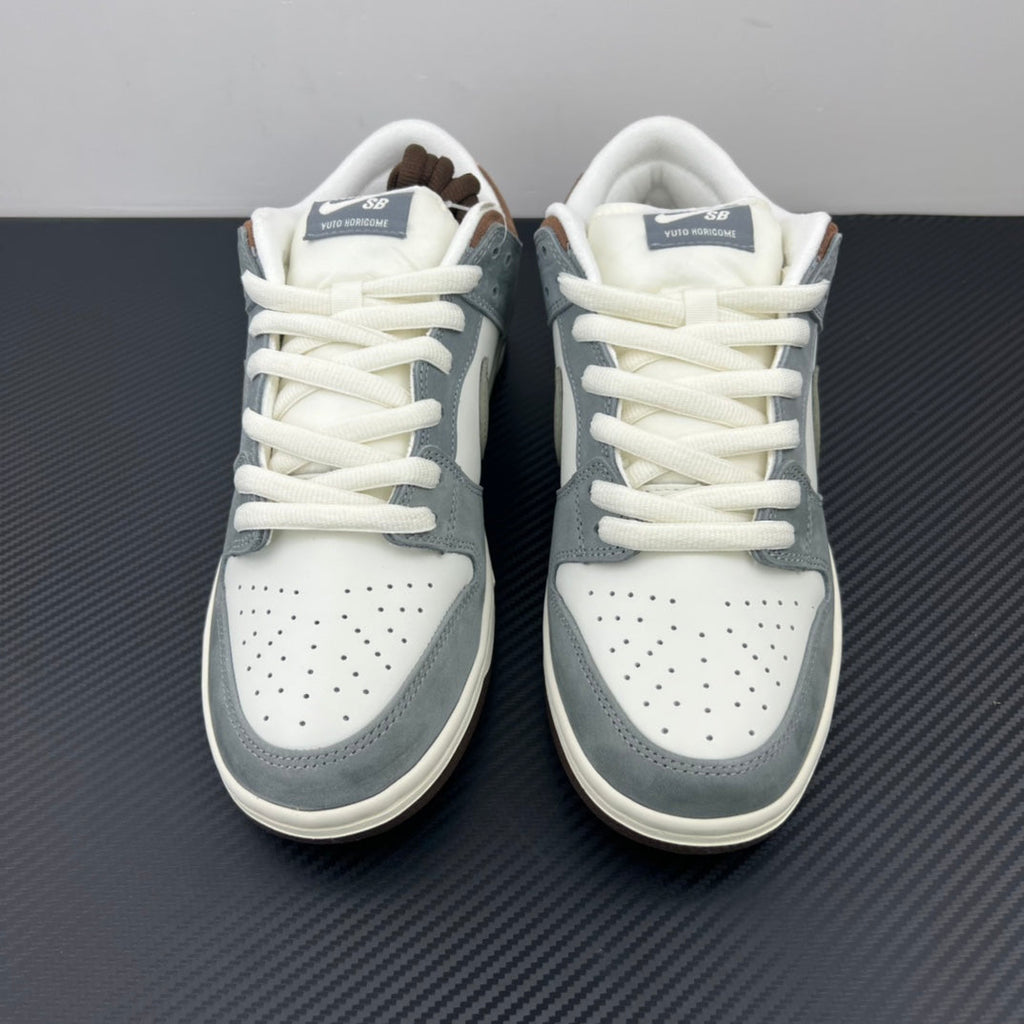Pair of light blue and white low-top sneakers with white laces and perforated toe