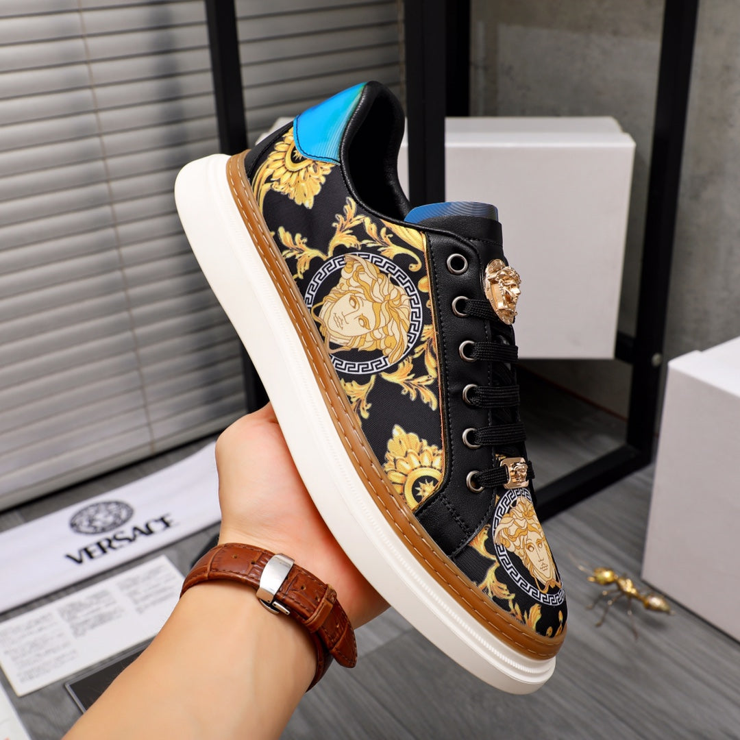 Versace sneakers in black with gold baroque print, held by hand, blue heel panel
