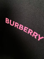 Black fabric close-up with pink BURBERRY lettering