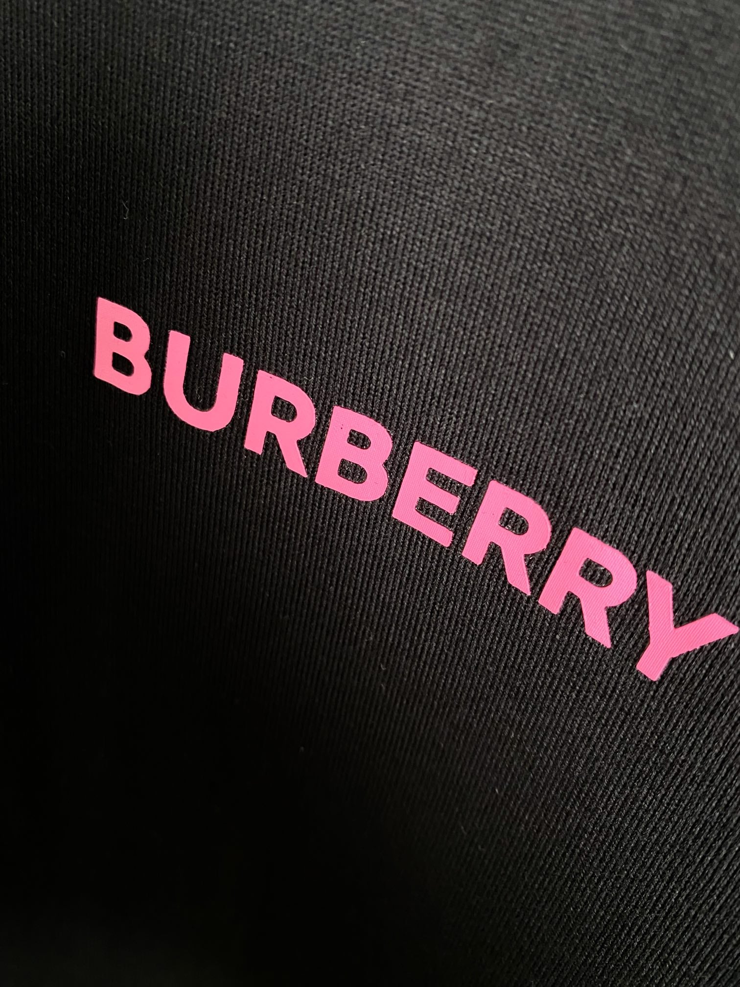 Black fabric close-up with pink BURBERRY lettering