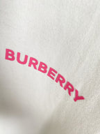 White T-shirt fabric close-up of pink BURBERRY lettering