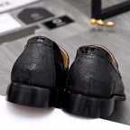 Black leather loafer heels with embossed textured vamp and tan interior.
