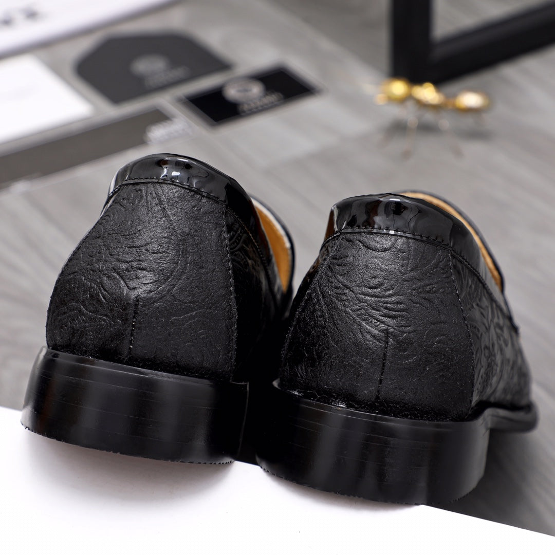 Black leather loafer heels with embossed textured vamp and tan interior.