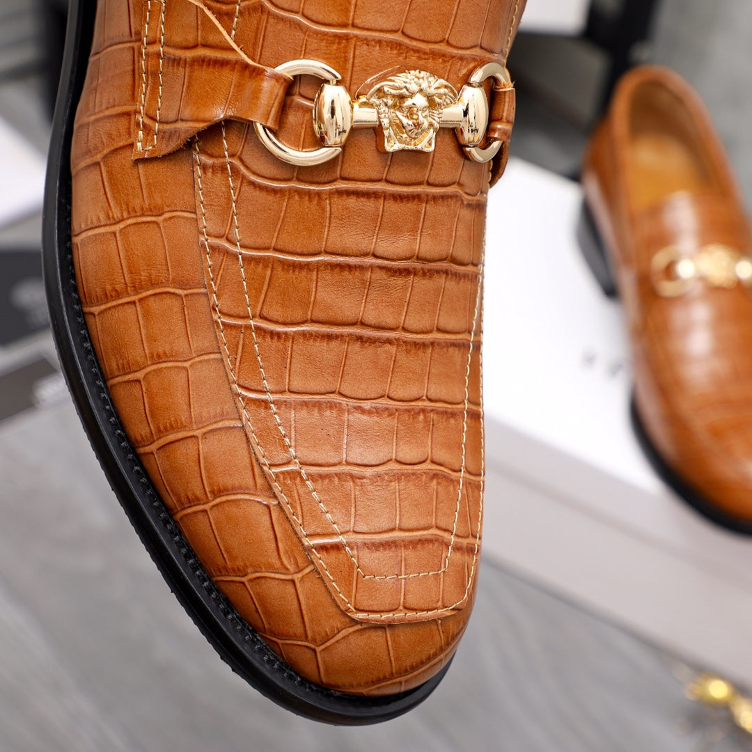 Versace luxury shoes, close-up of brown loafer strap with gold bit buckle hardware