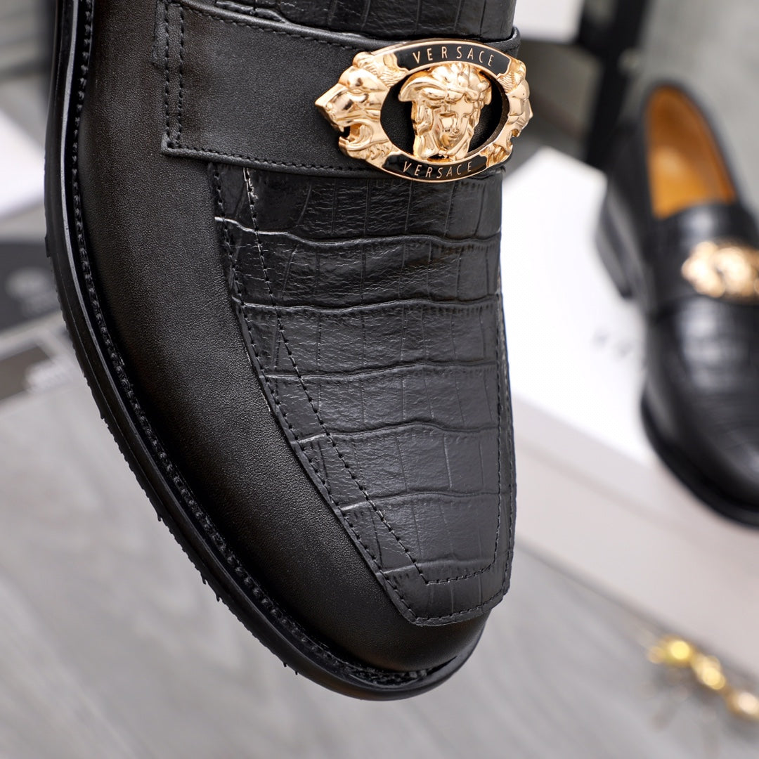 Men's Versace black leather loafer close-up with gold crest medallion on strap
