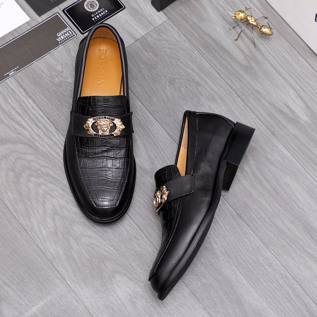Pair of men's Versace black leather loafers with gold crest buckle and embossed vamp