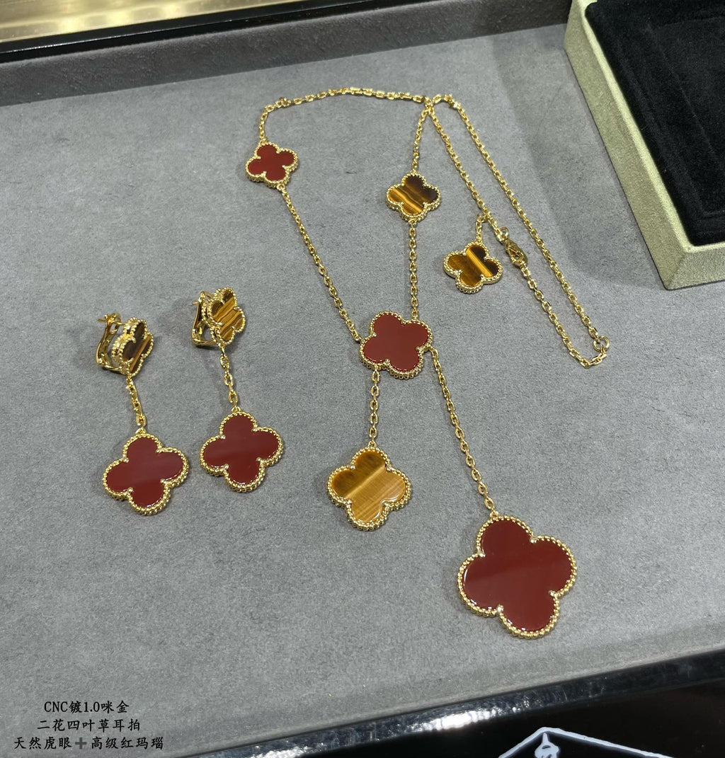 Set of gold-tone clover earrings with red enamel, including drop and stud styles