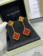 Gold-tone clover drop earrings with red enamel and small clover studs