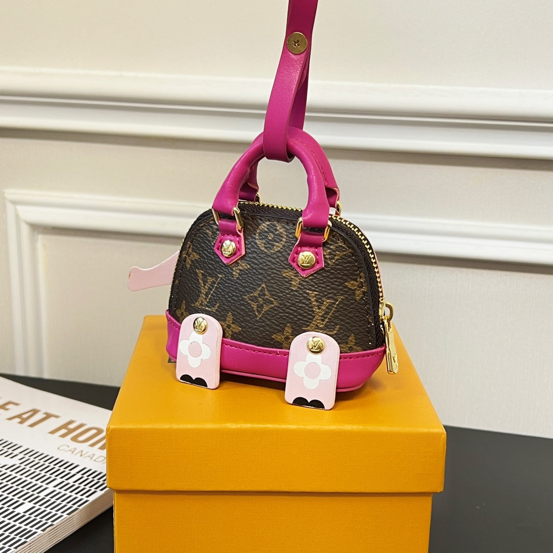 Louis Vuitton mini handbag charm with magenta handle, brown monogram base and pink panel