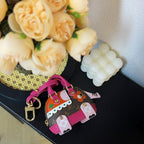 Small Louis Vuitton mini bag with brown monogram, pink straps, colorful front appliqués