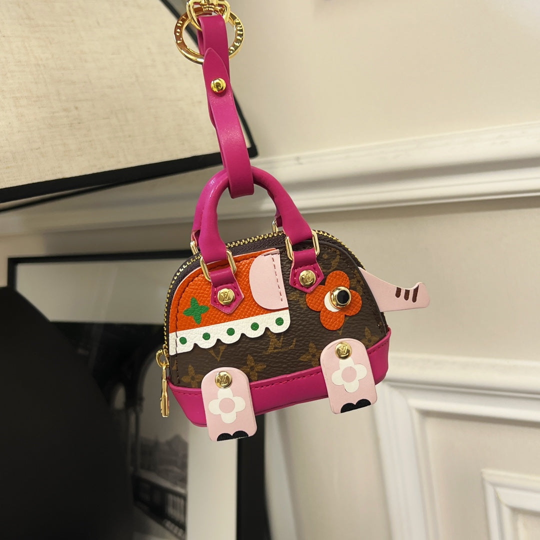 Louis Vuitton mini handbag charm with magenta handle, brown monogram and colorful character patches