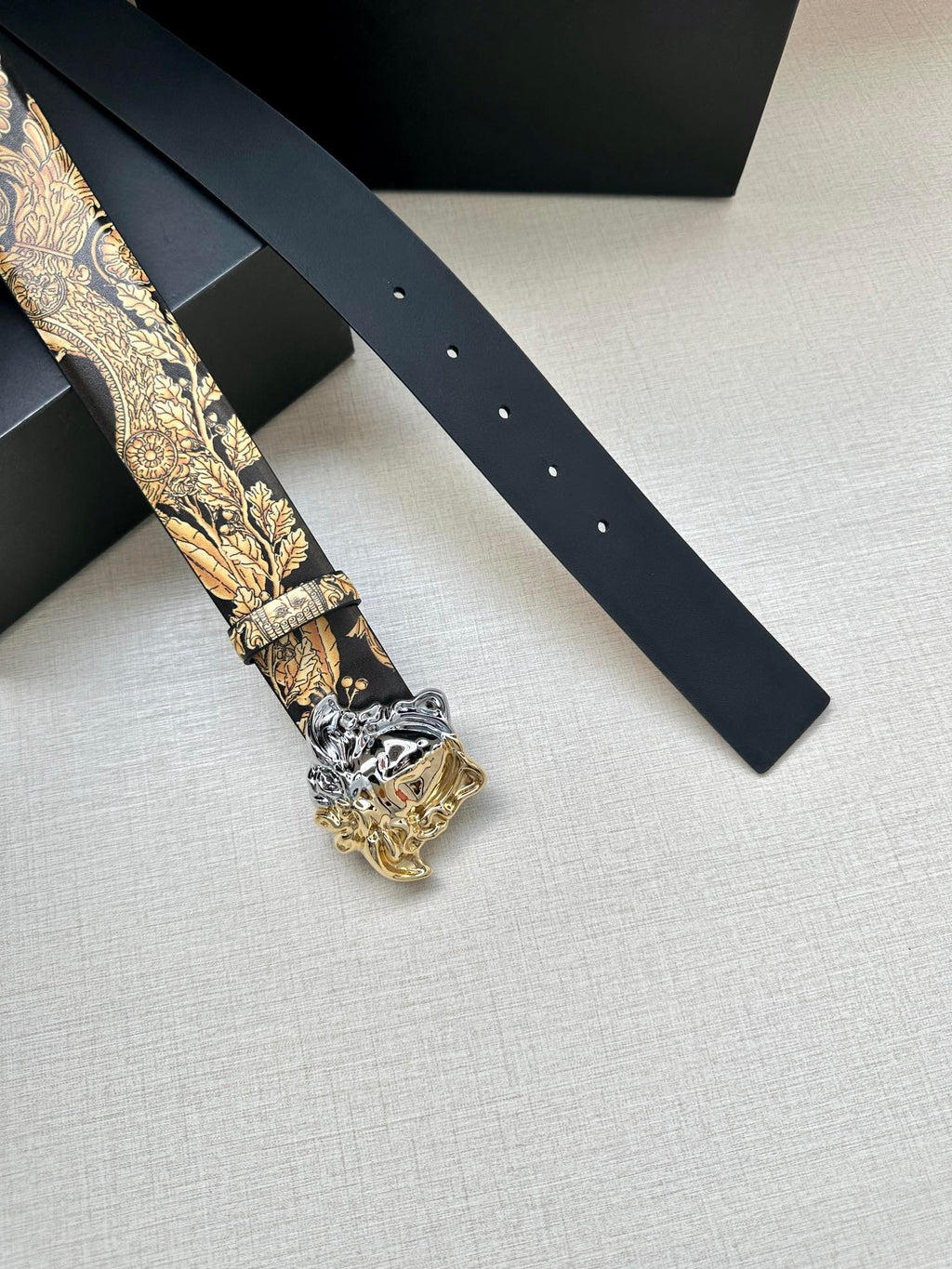 Leather belt details: gold baroque printed strap with silver Medusa buckle, dark navy.