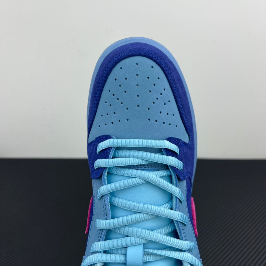 Low-top sneaker toe with perforations, light-blue laces, and dark-blue overlay.