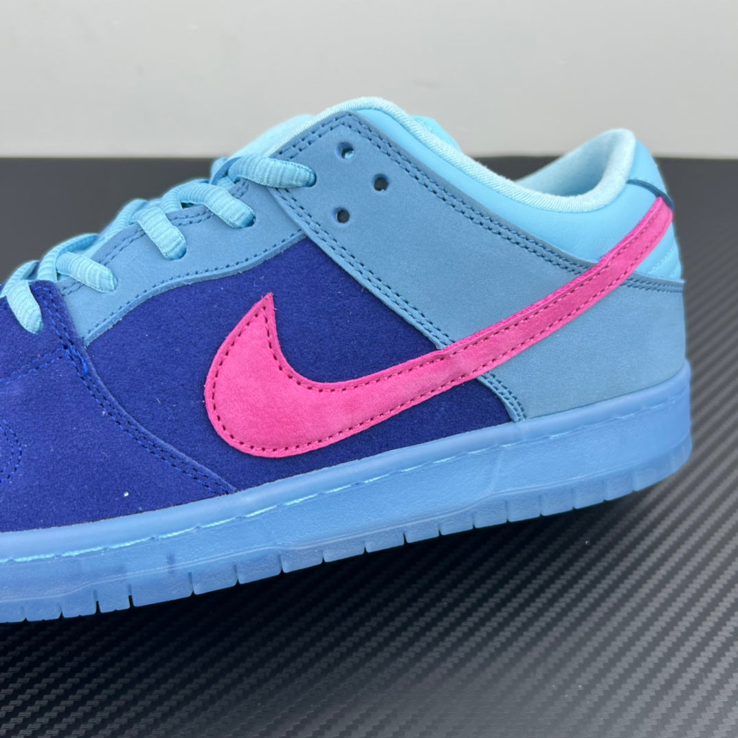 Low-top sneaker close-up with navy suede, light-blue leather, and pink Nike swoosh.