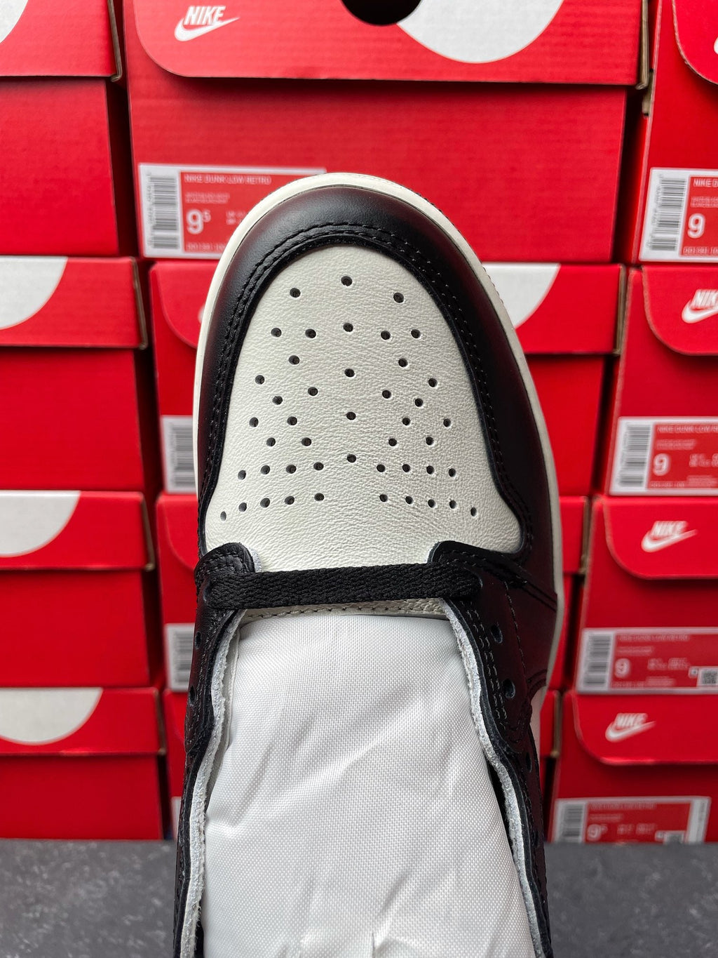 High-top sneakers, top of shoe view, perforated toe area with black laces and lining