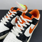 Low-top sneakers close-up with white laces, black overlays, orange Swoosh, patterned side panels.