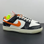 Low-top sneakers with white and black panels, orange Swoosh, white laces, chunky sole.