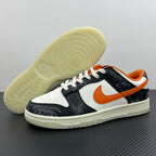 Low-top sneakers shown from side; white sole, black and white upper, orange Swoosh.