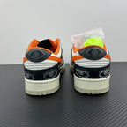 Low-top sneakers heel view: black rear panels, orange lining, white sole, side logo patch.