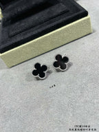 Van Cleef & Arpels quatrefoil stud earrings close-up, dark enamel with silver outline
