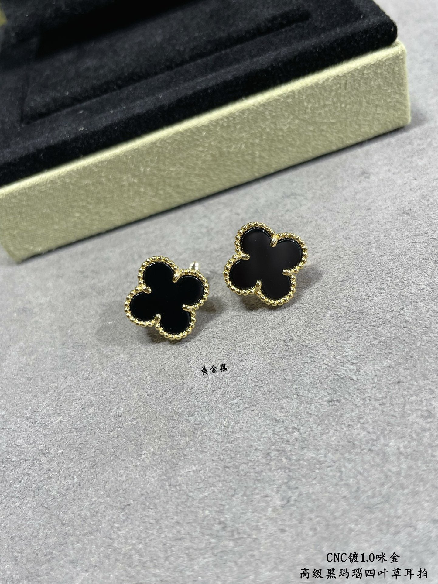 Van Cleef & Arpels quatrefoil stud earrings close-up, black enamel with gold outline