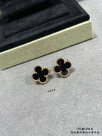 Van Cleef & Arpels quatrefoil stud earrings close-up, dark enamel with gold outline