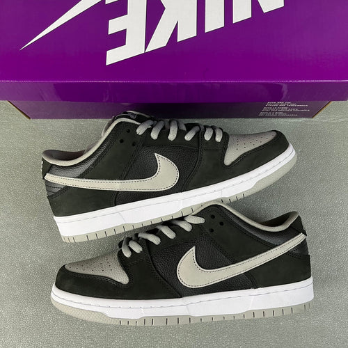 Pair of black low-top skate shoes with white swooshes and thick white midsoles