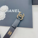 Chanel belt close-up in dark blue leather with gold-toned CC buckle and logo strap