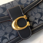 Navy patterned handbag detail with gold D-ring clasp and stitched leather trim