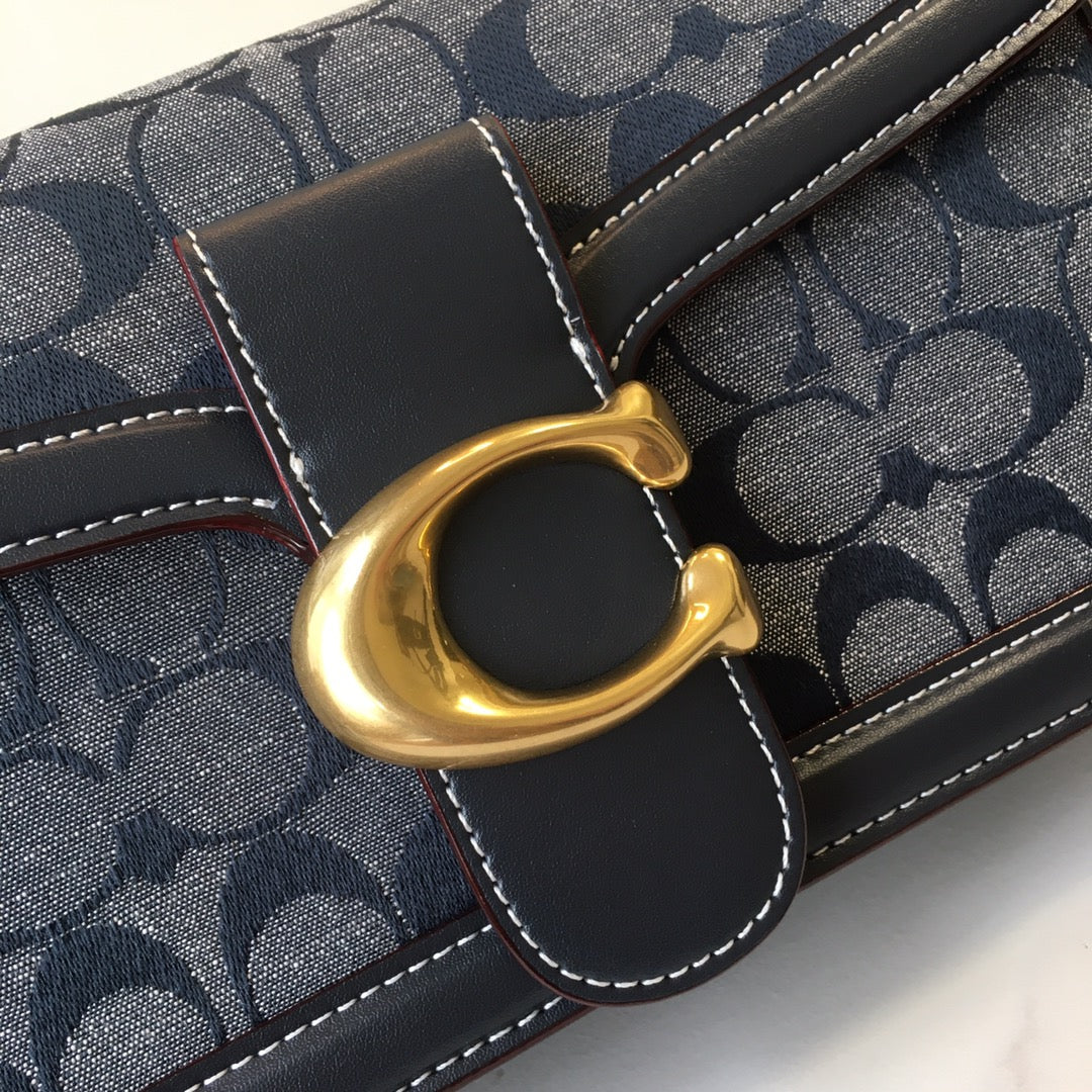 Navy patterned handbag detail with gold D-ring clasp and stitched leather trim
