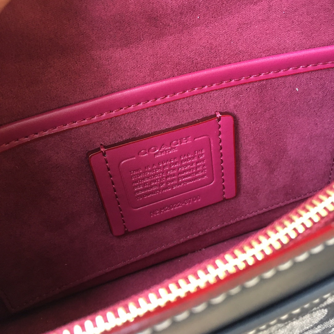 Burgundy interior fabric with leather brand tag and visible red zipper trim