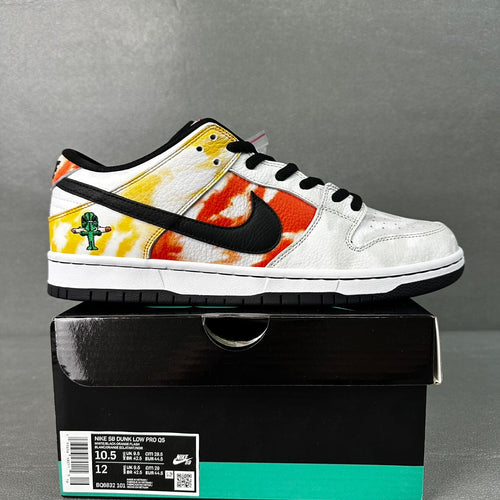 White low-top sneakers with yellow and orange graphic panels, black swoosh, black laces
